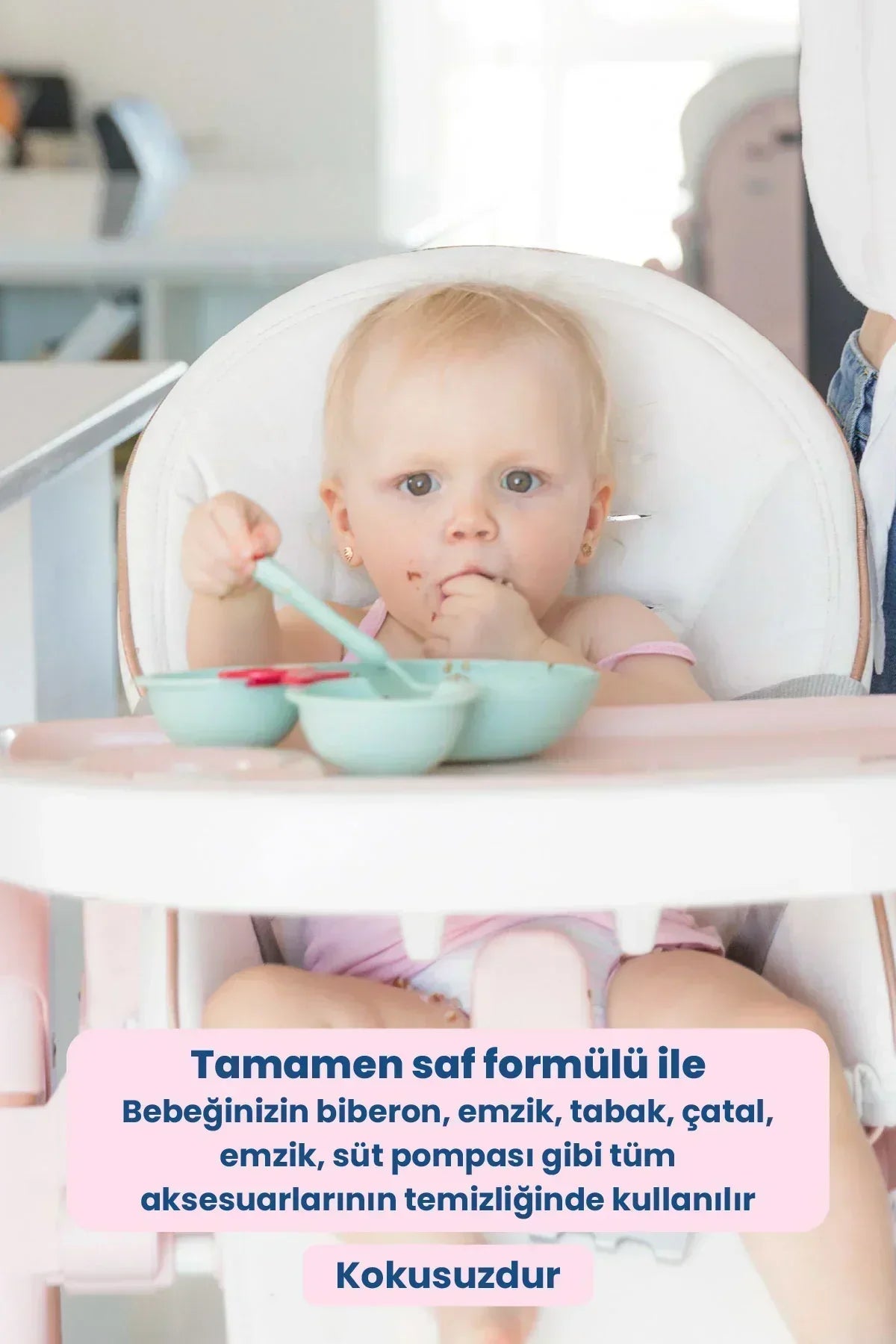 Yüksek sandalyede oturan bebek, önünde mavi beslenme tabaklarıyla yiyecek yiyor