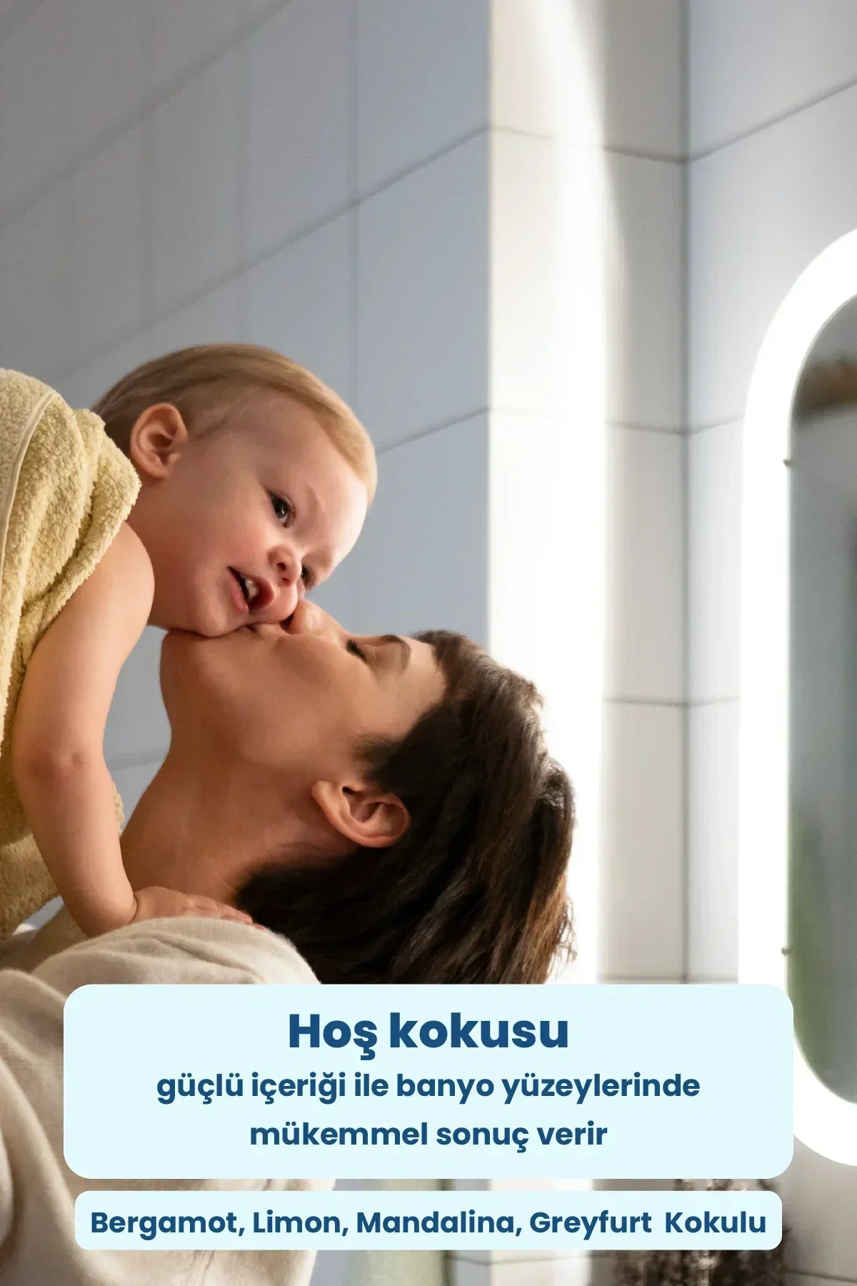 Banyo ayna önünde, sarı havluyla sarılmış bebekle anne şefkatle öpüşüyor, hoş kokulu temizlik ürünü tanıtımı